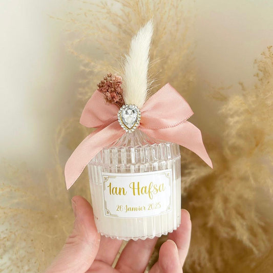 Bougie cadeau invité Queen avec nœud rose, plume blanche et strass, personnalisée avec prénoms et date.