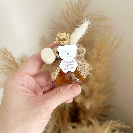 Cadeau invité baptême : petit pot de miel personnalisé avec ourson miroir, jute naturelle, fleurs séchées et cuillère en bois.