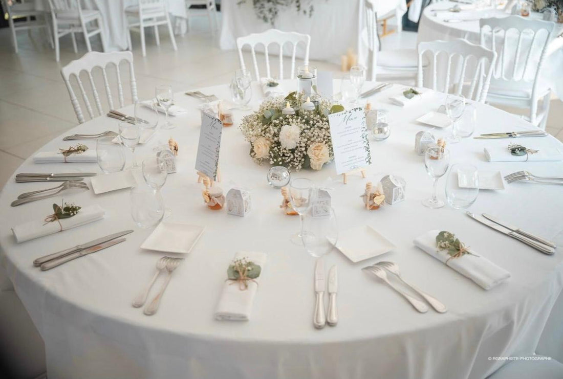 Table de mariage élégante avec décoration florale blanche et pots de miel chic personnalisés comme cadeaux invités