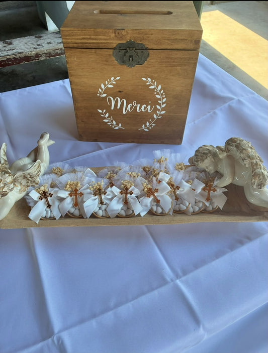 Cadeaux invités Dragées Angels avec rubans blancs et croix dorées devant une urne en bois Merci pour le baptême d'Enzo et Angelo