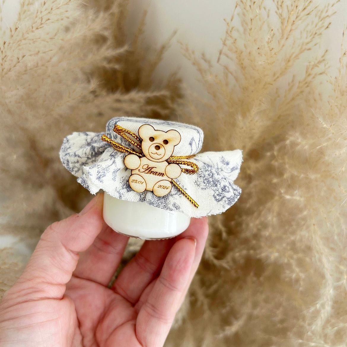 Cadeau invité baptême : bougie avec tissu marbré, nœud doré et décoration ourson en bois personnalisé.