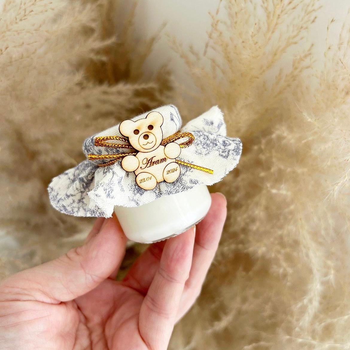 Cadeau invité baptême : bougie avec tissu marbré, nœud doré et décoration ourson en bois personnalisé.
