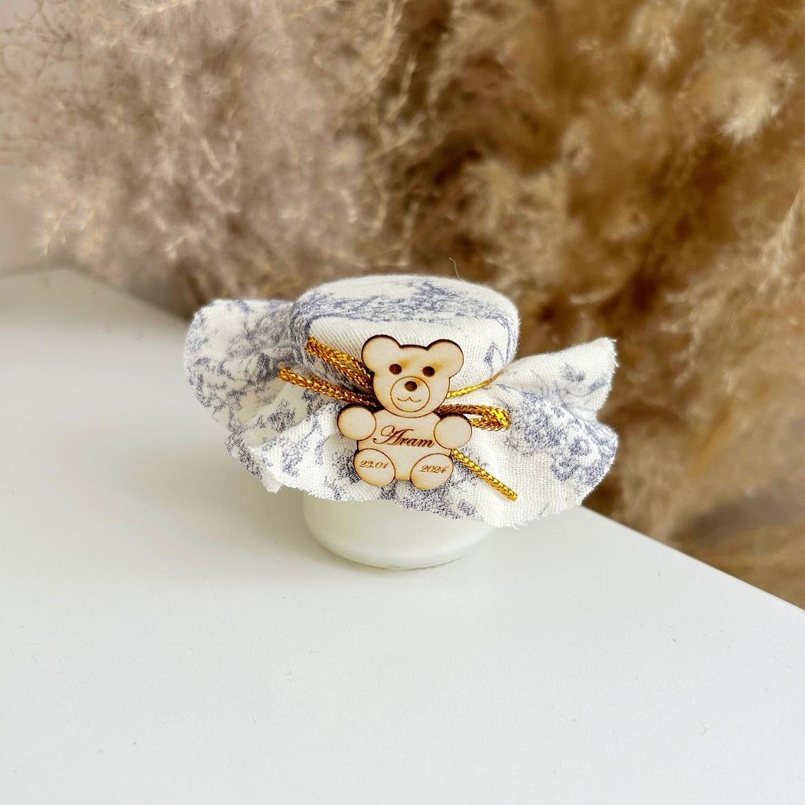 Cadeau invité baptême : bougie avec tissu marbré, nœud doré et décoration ourson en bois personnalisé.