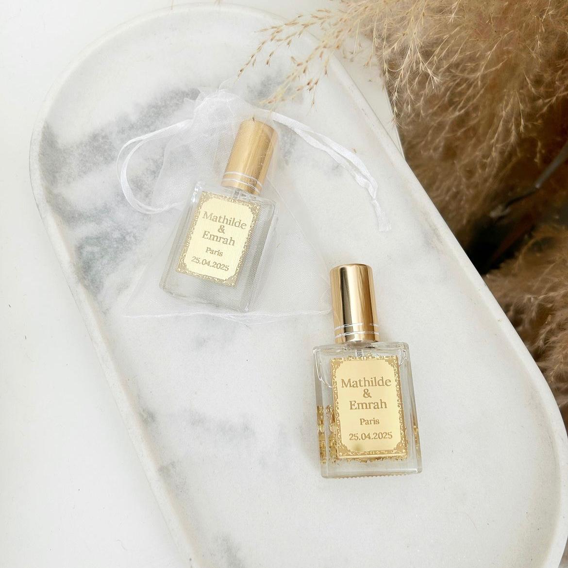 Cadeau invité : mini parfum Dubai avec capuchon doré, flacon transparent et étiquette personnalisée prénoms, ville et date.