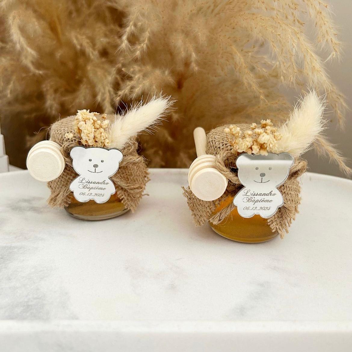 Cadeau invité baptême : petit pot de miel personnalisé avec ourson miroir, jute naturelle, fleurs séchées et cuillère en bois.