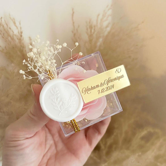 Cadeau invité : rose de savon Soélia rose en boîte plexi avec sceau blanc, fleurs séchées et plaque dorée personnalisée.